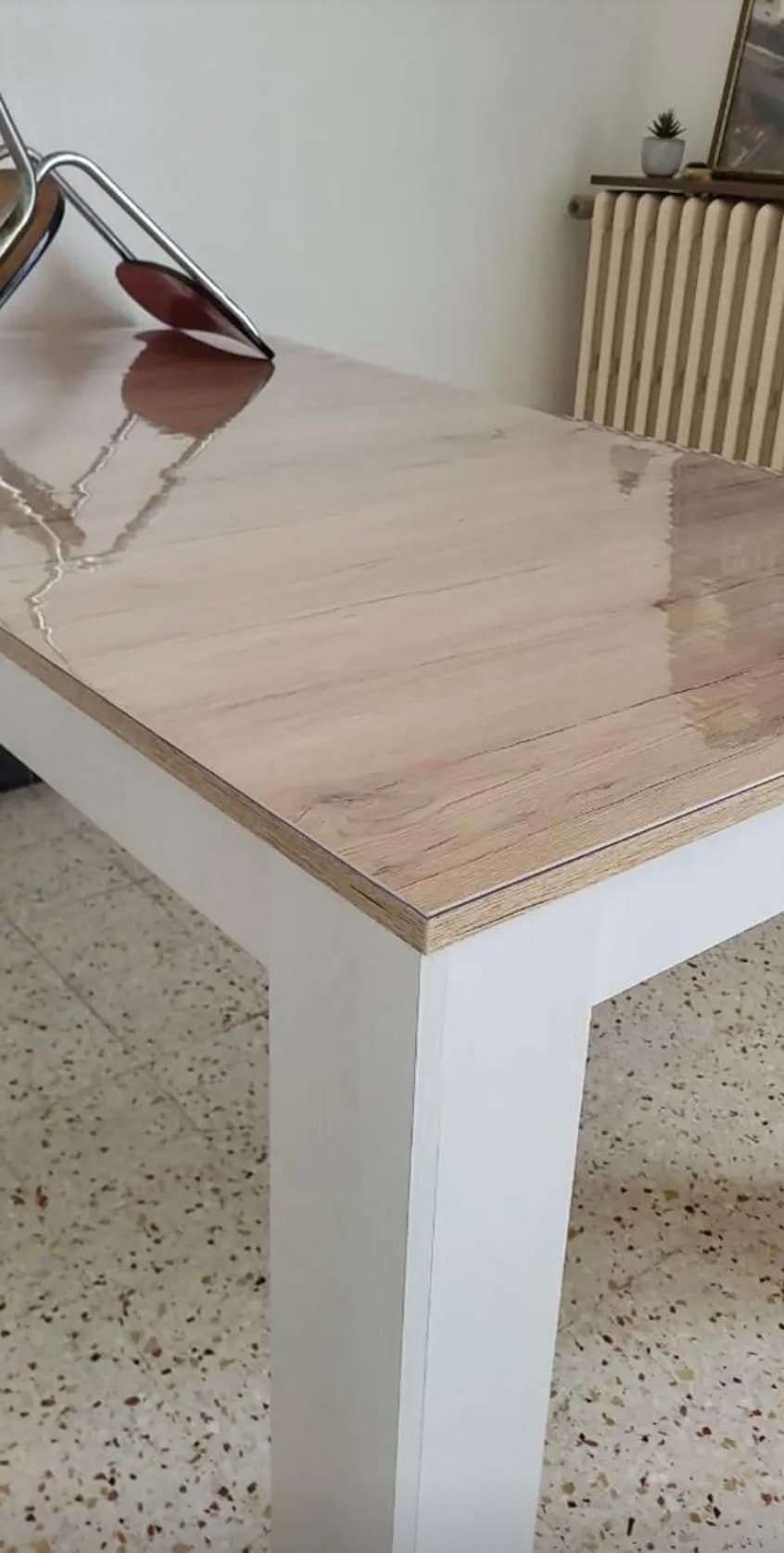 Bright table top on white legs with mat gloss; a cast iron radiator in the background