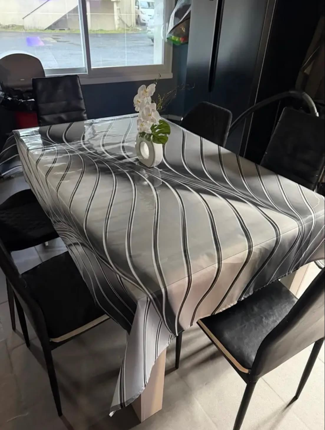 A mat spread on a striped tablecloth protects the fabric on the dining room table