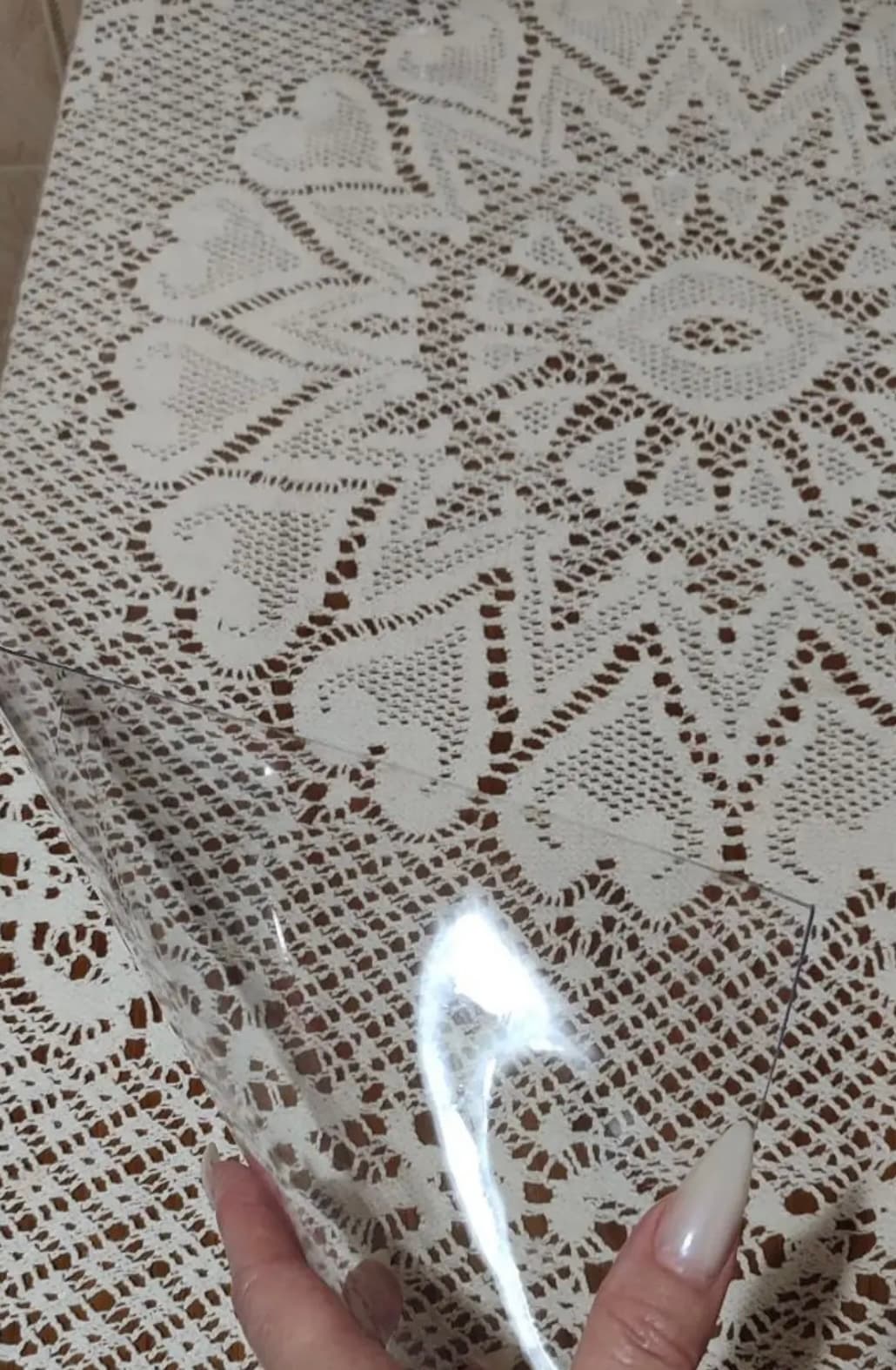 Transparent mat on a crochet tablecloth - the lace pattern can be seen through the overlay