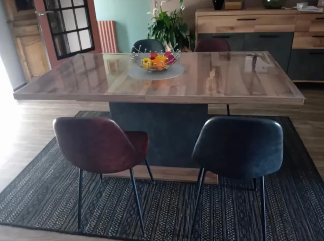 Knotted wood extendable table with fruit basket; two leather chairs on the carpet