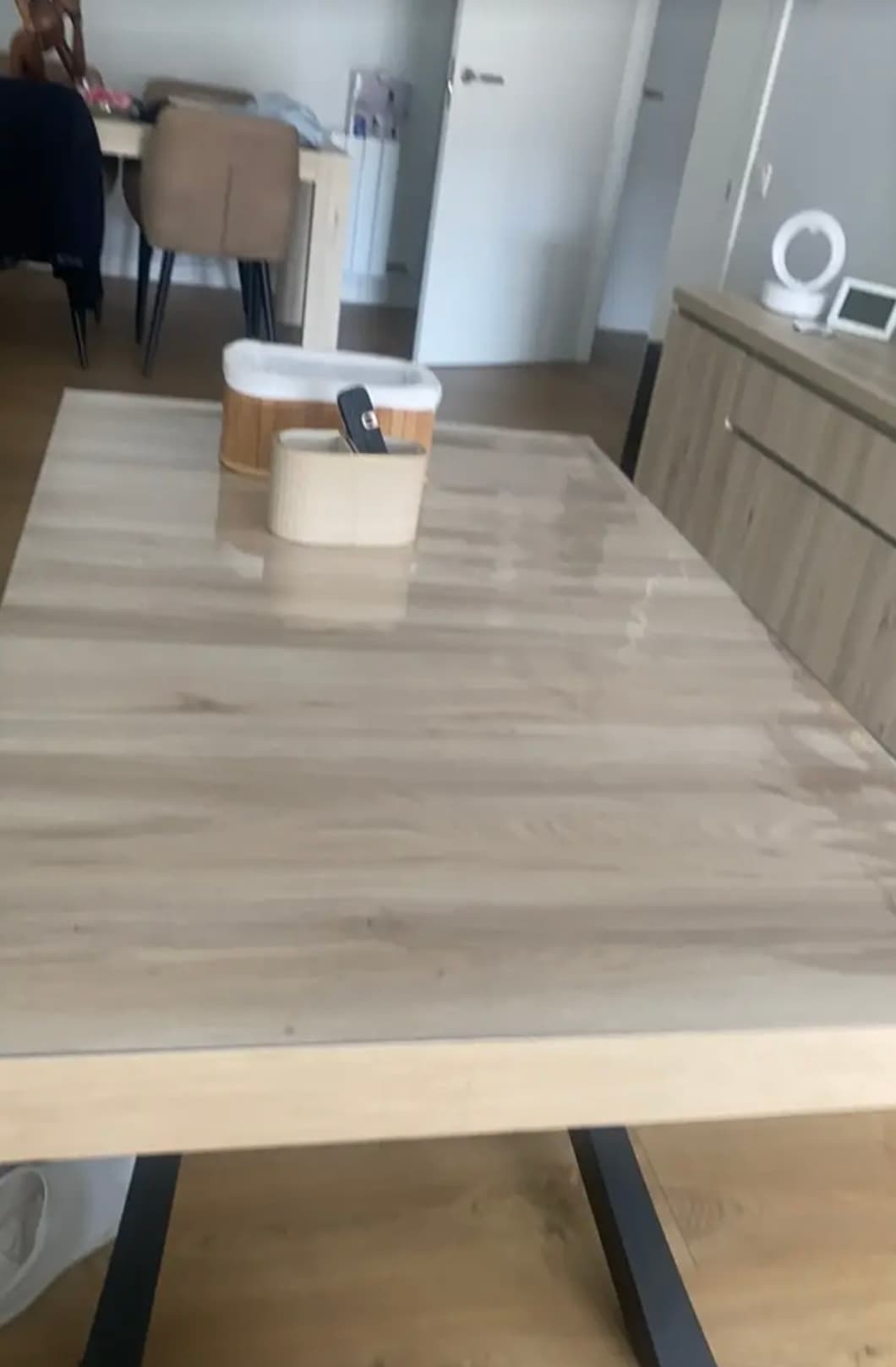 Bright table in the living room with wooden containers; the mat reflects light from the window