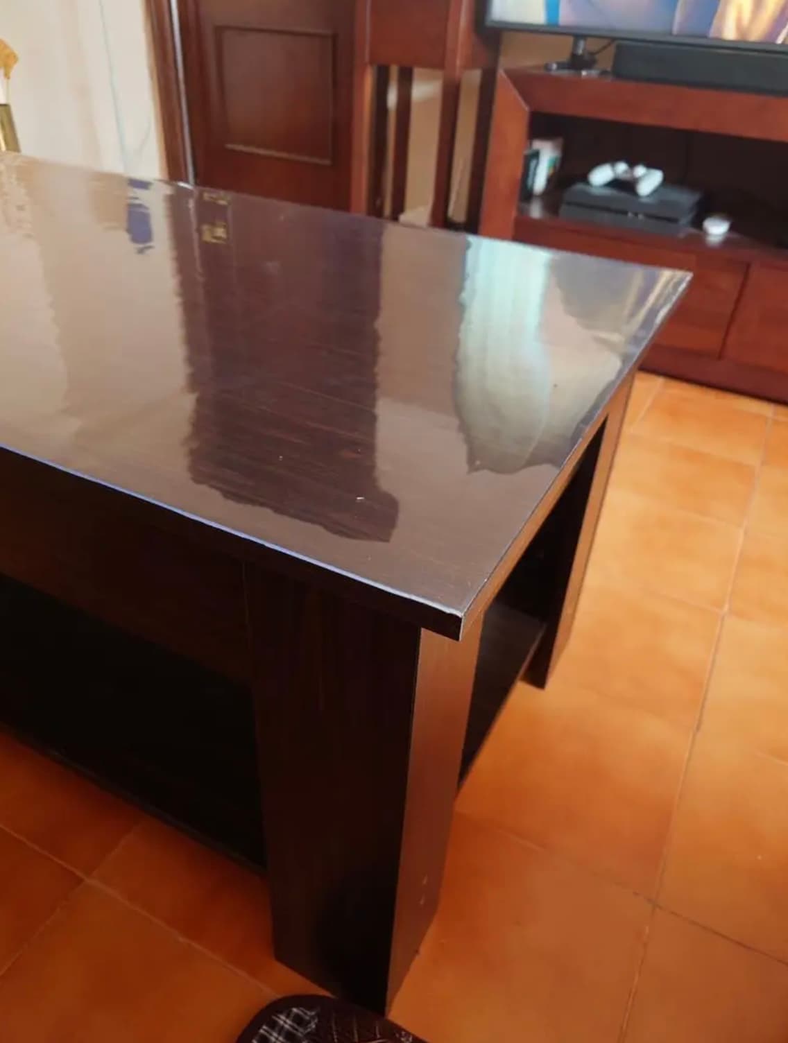 Dark console with wenge in the living room, countertop under a transparent mat, terracotta on the floor